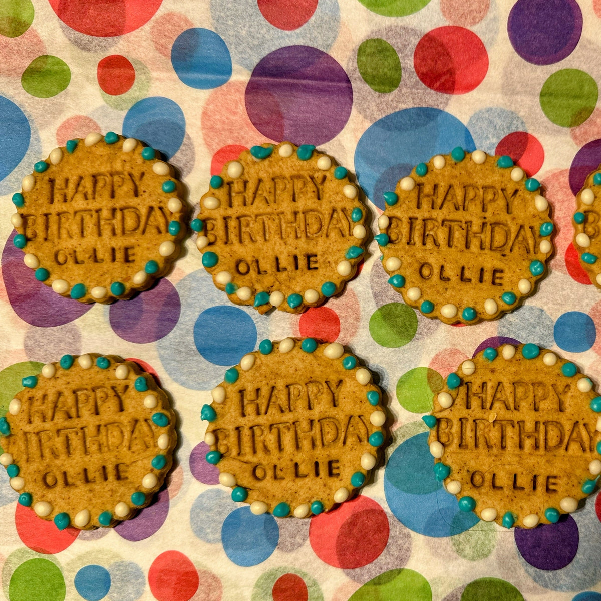 Six personalised Happy Birthday dog biscuits with blue and white icing