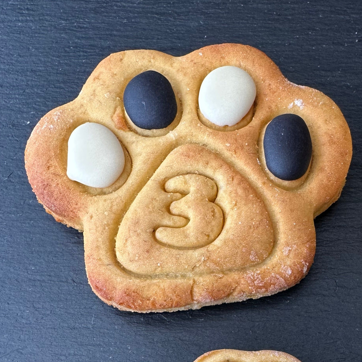 Large number paw dog biscuit with black and white icing