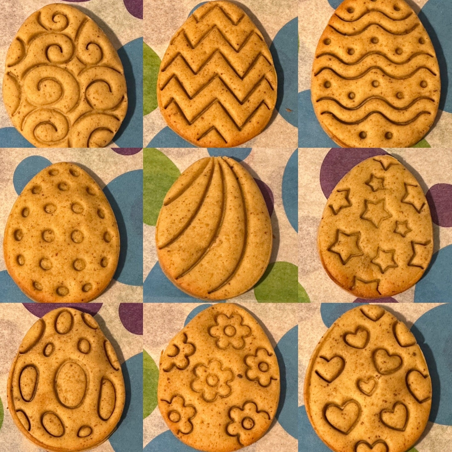 A selection of stamped Easter egg-shaped grain free dog biscuits with various patterns such as zigzag, heart, and floral designs.