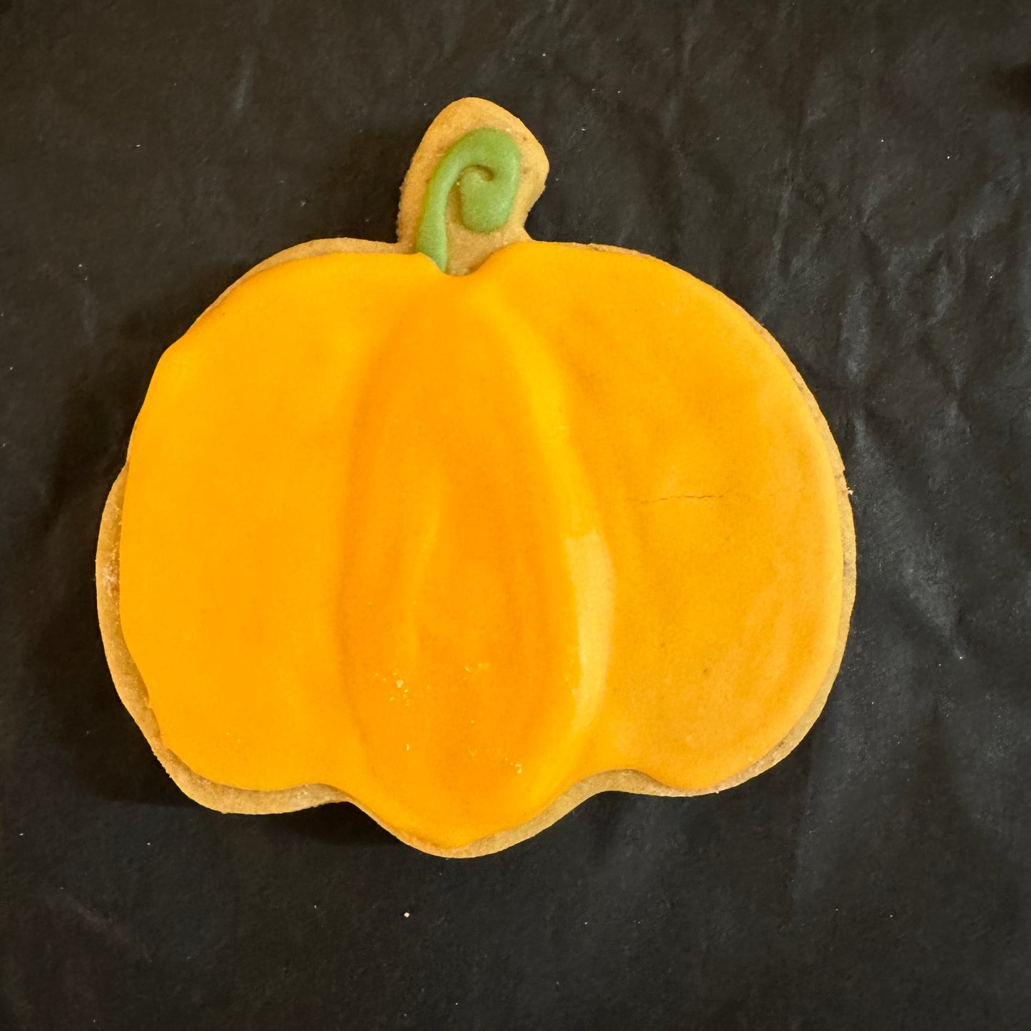 A dog treats designed to look like a pumpkin-shaped cookie.