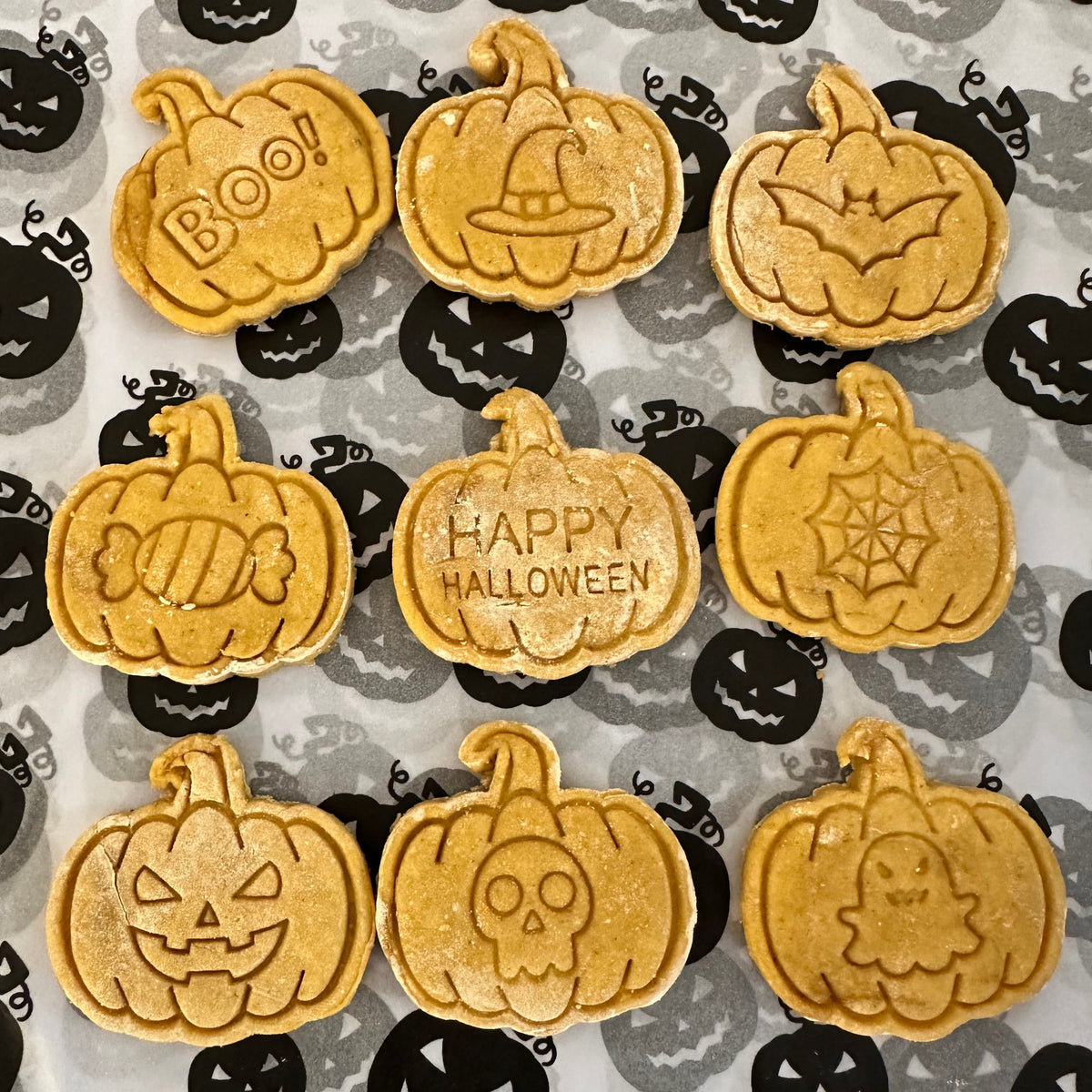 Selection of pumpkin-shaped dog biscuits with Halloween stamps