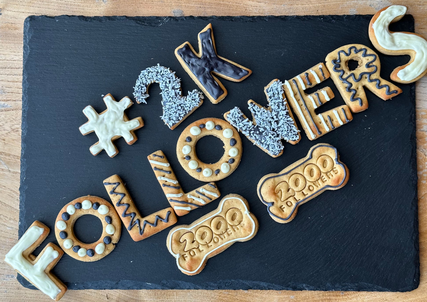 A selection of dog biscuits spelling out "# 2K FOLLOWERS"