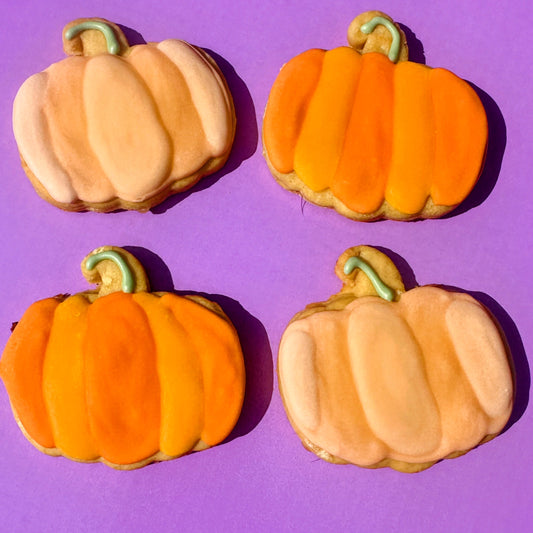 Hand-decorated pastel pumpkin dog biscuits in autumn colours
