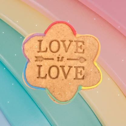 Flower-shaped sign with 'LOVE is LOVE' text on a colorful background