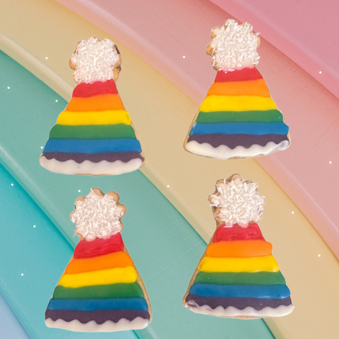Four rainbow-coloured party hat cookies with white frosting on a colourful background