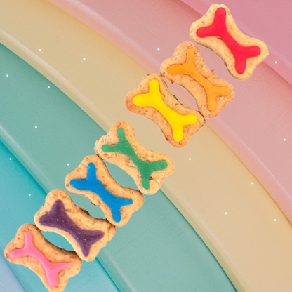 Colorful bone-shaped cookies on a pastel background