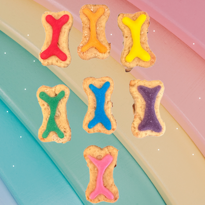 Colorful bone-shaped cookies on a pastel background