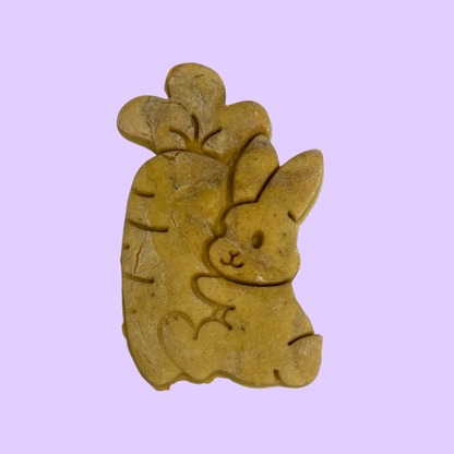 Bunny cuddling a carrot dog biscuit from Percys Pawfect Pantry