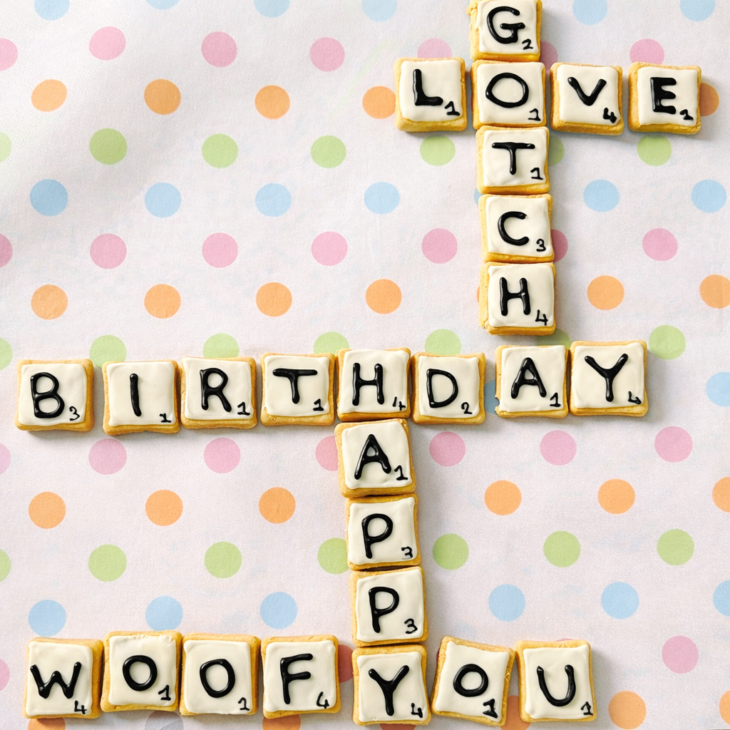 Scrabble tiles spelling 'Happy Birthday Woof' on a polka dot background