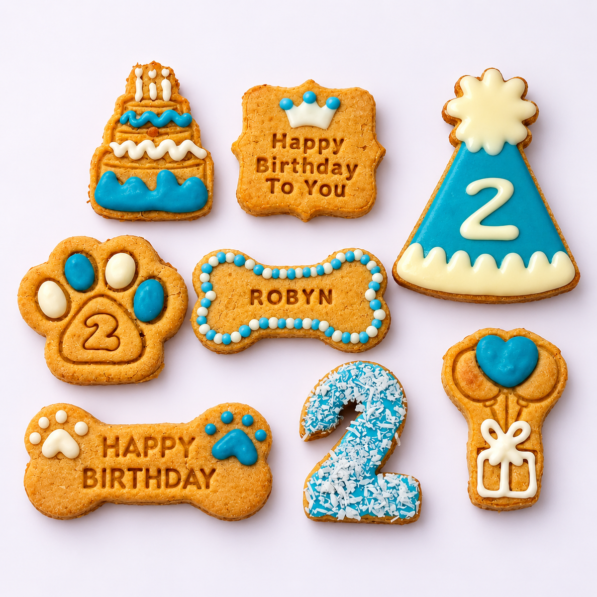 Personalised dog birthday biscuit set with blue and white icing, including Robyn’s name, number 2 biscuits and a matching large party hat biscuit.