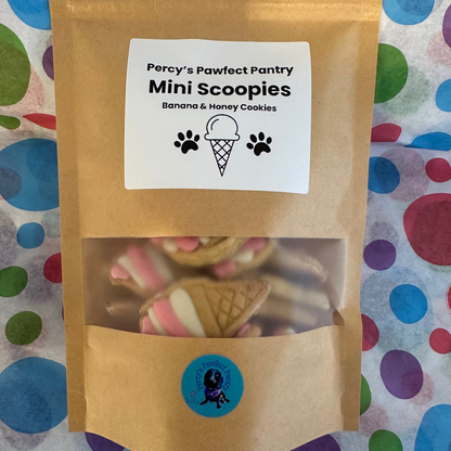 Kraft paper pet treat package labeled 'Percy's Pawfect Pantry Mini Scoopies' on a polka dot background.
