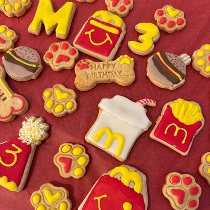Collection of cookies shaped like McDonald's logos and items on a red background
