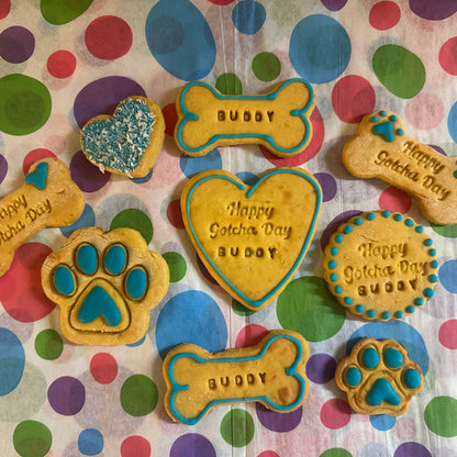 Dog treats shaped like bones, hearts, and paws with 'Happy Gotcha Day Buddy' text on a polka dot background.