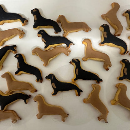 Dachshund-shaped cookies in black and brown on a white surface