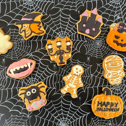 Halloween-themed cookies on a spider web background