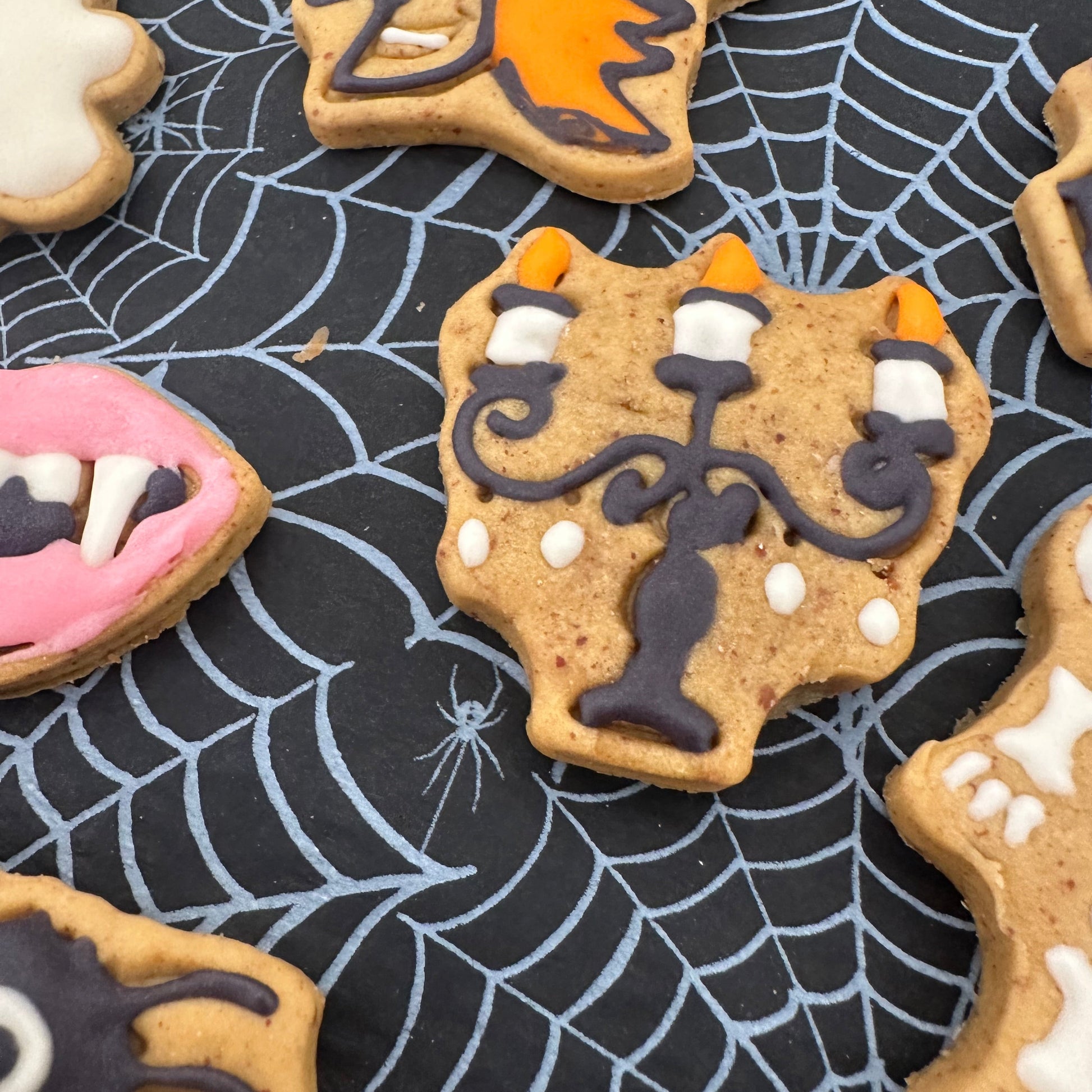 Halloween-themed cookies on a spider web background