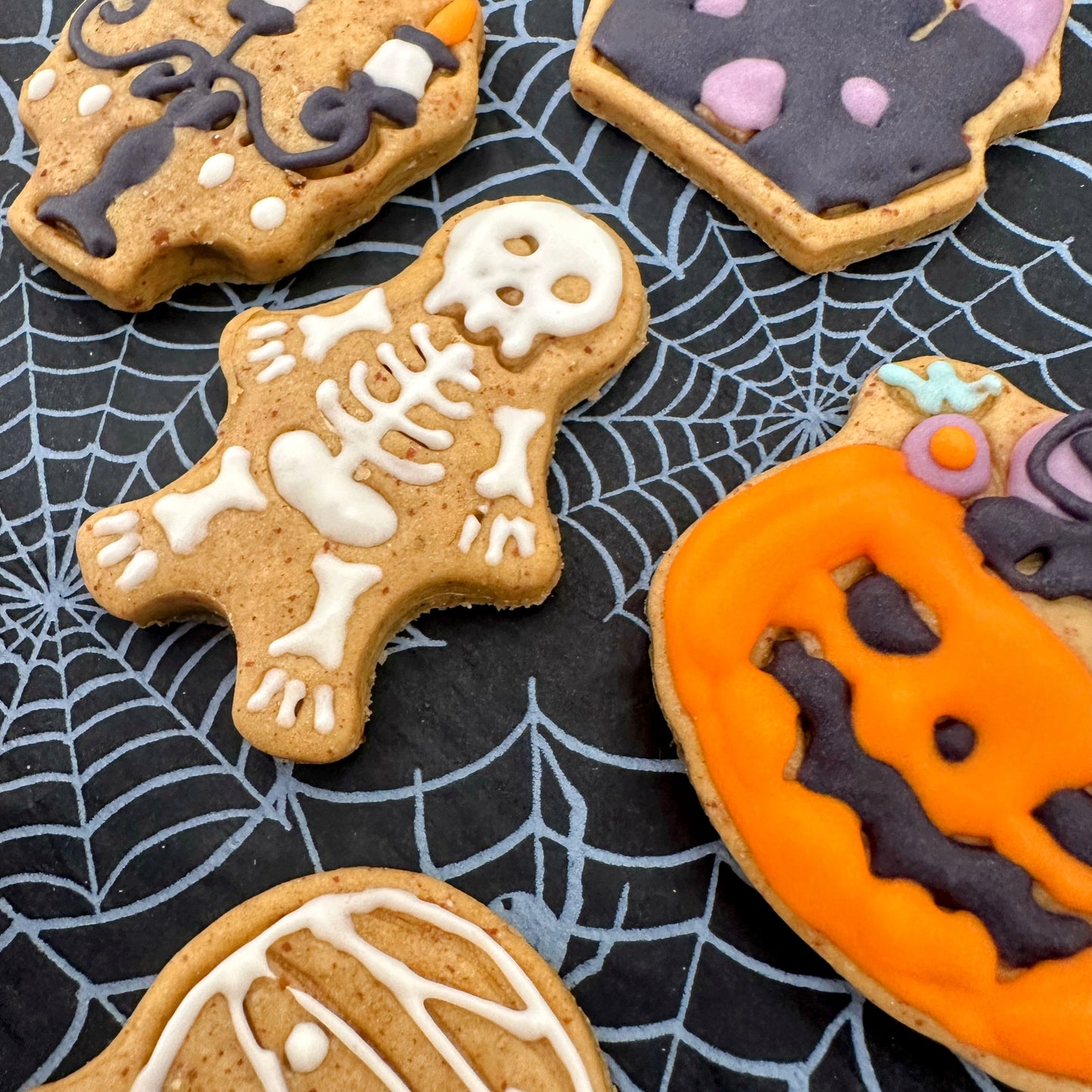 Halloween-themed cookies on a spider web background