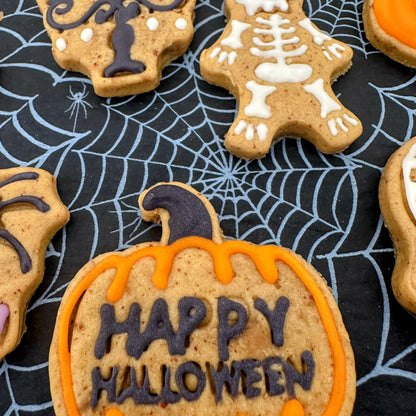 Halloween-themed cookies on a black surface with spider web design