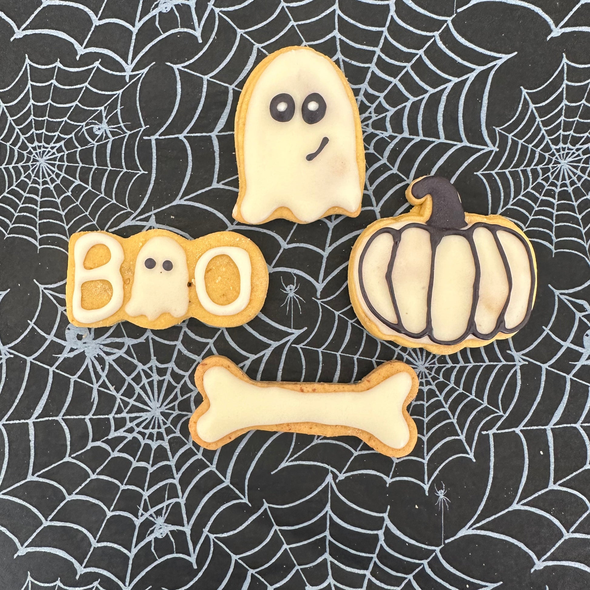 Halloween-themed cookies on a spider web background