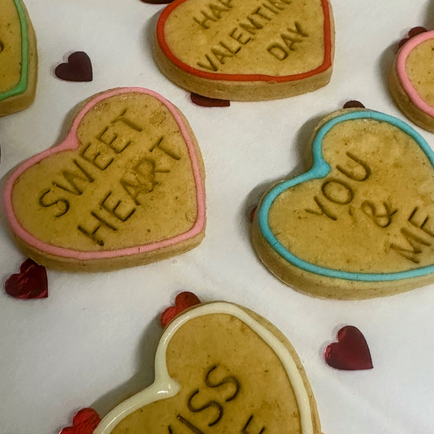 Heart-shaped cookies with Valentine's Day messages on a white background