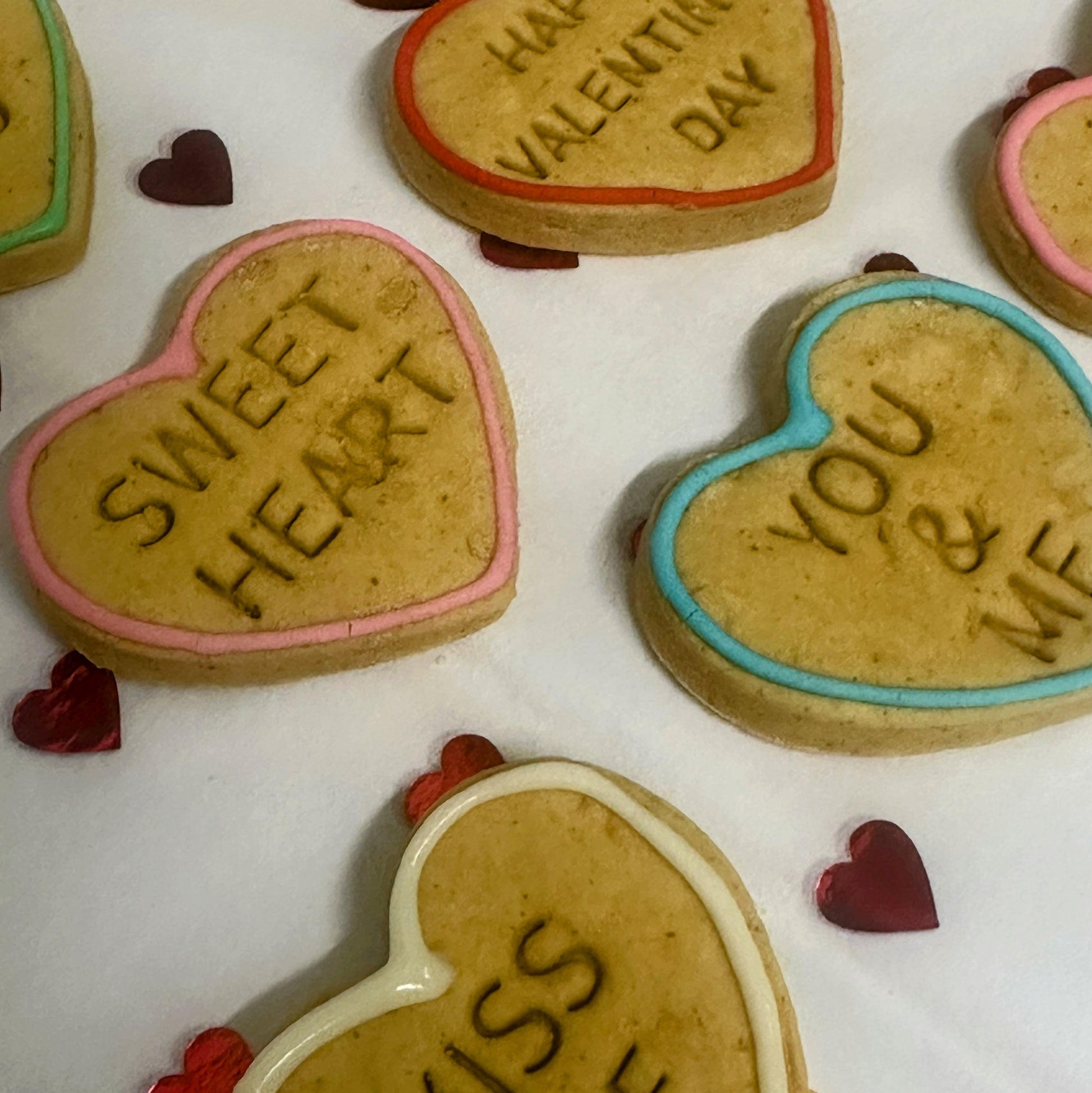 Heart-shaped cookies with Valentine's Day messages on a white background
