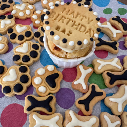 Dog-themed birthday cookies with 'Happy Birthday' icing on a colorful polka dot background