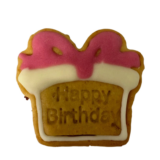 Cookie shaped like a birthday present with pink and white icing on a white background