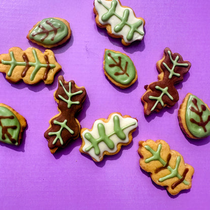 Leaf-shaped cookies with green icing on a purple background