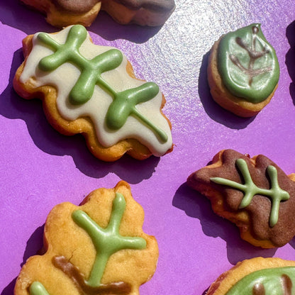 Cookies with green icing shaped like leaves on a purple background