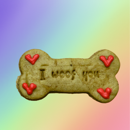 A bone-shaped dog biscuit with 'I woof you' written on it and decorated with red love hearts.