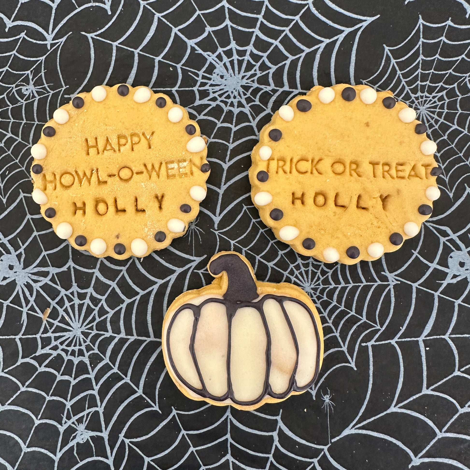 Halloween-themed cookies with text on a spider web background