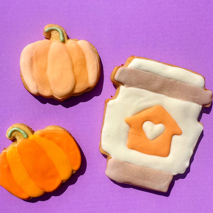 Decorative cookies shaped like pumpkins and a jar with a heart on a purple background